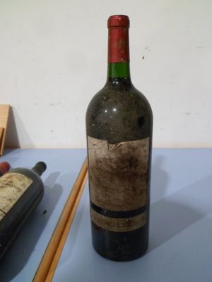 une bouteille de vin posée sur une table à côté de baguettes