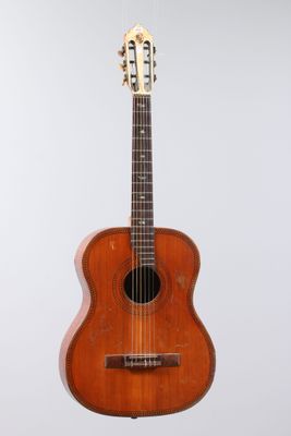 a close up of a guitar on a stand against a white background