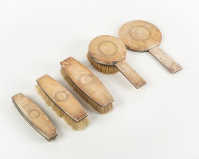 four wooden brushes are lined up in a row on a white surface