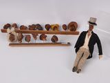 a figurine of a man sitting next to a rack of teddy bears