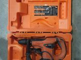 une boîte à outils orange contenant des outils, posée par terre