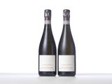 two bottles of wine sitting on top of a white table