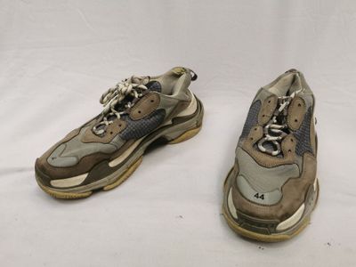 Deux paires de baskets sont posées sur une surface blanche
