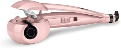 le sèche-cheveux rose est posé sur une surface blanche