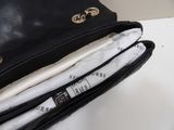 a black purse sitting on top of a white table