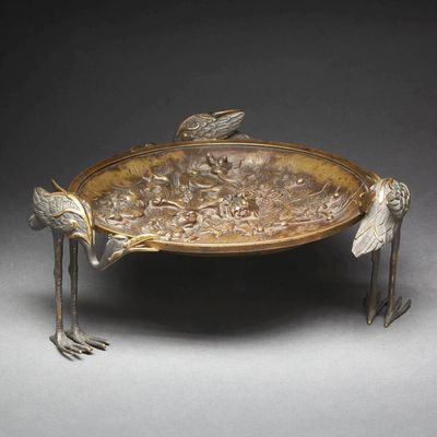 a metal tray with birds on it on a table