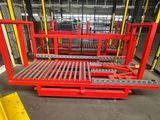 a close up of a red pallet in a warehouse with other pallets