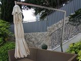un canapé et un parasol sur une terrasse bordée d'un mur en pierre