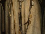 painting of a monk holding a rosary and a rosary in his hands