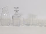 des bouteilles et des verres sont alignés sur une surface blanche