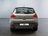 the rear end of a silver car in a room with a white wall