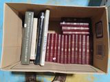une boîte remplie de livres posée sur une table, avec une personne debout à côté