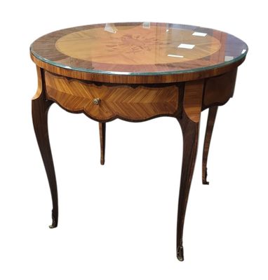 une image représentant une table ronde avec un plateau en verre sur fond blanc