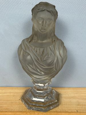 un buste en verre représentant une femme assise sur une table