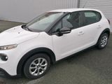 a small white car parked in front of a building