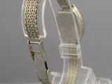 un gros plan d'un bracelet en argent posé sur un présentoir transparent