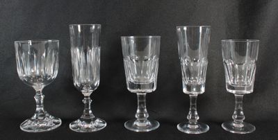 quatre verres à vin sont alignés sur une surface noire