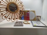 une table sur laquelle se trouvent un miroir, un cadre photo et une paire de ciseaux