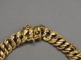 an image of a gold bracelet on a gray surface