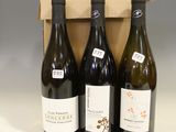 three bottles of wine are in a cardboard box on a table