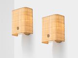 pair of bamboo sconces mounted on a wall in a white room