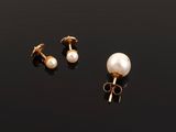 a pair of pearl and gold earrings on a black surface