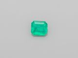 an emerald stone on a white surface