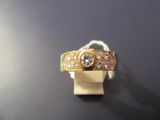 a gold ring with three diamonds on it on a black surface
