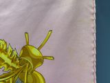 a close up of a yellow insect on a pink cloth