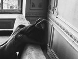 black and white photograph of a naked woman sitting on a couch in a room