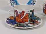 two cups and saucers with colorful designs on them