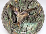 a plate with a bird on it that is on a table