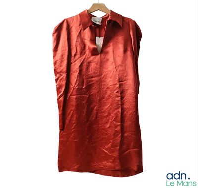 une image représentant une chemise rouge suspendue à un cintre sur fond blanc