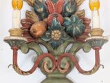 a wall sconce with a bunch of flowers and candles on it