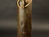 an old metal canister with a rope handle on a black background