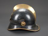 an old helmet with a gold rim sits on a gray surface