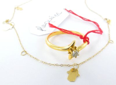 deux bagues en or et un bracelet en fil rouge orné d'une breloque en forme de main de Fatima en or