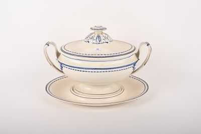un bol et une soucoupe blancs et bleus posés sur une assiette