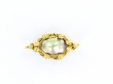un gros plan d'une bague en or renfermant une perle
