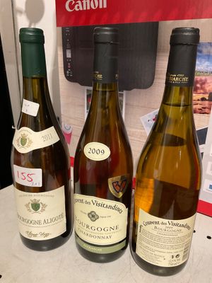 trois bouteilles de vin posées sur une table, l'une à côté de l'autre