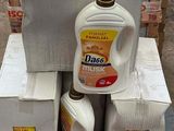 une pile de cartons sur laquelle est posée une bouteille de lessive