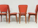 trois chaises rouges placées les unes à côté des autres sur une surface blanche