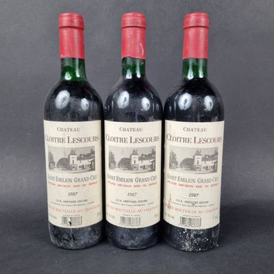 three bottles of red wine sitting next to each other on a table