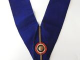 a close up of a blue collar with a medallion on it
