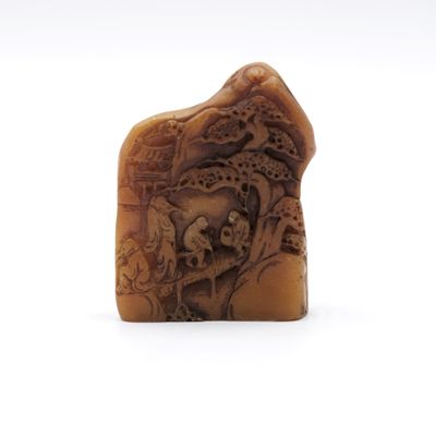 une image représentant un morceau de bois sculpté sur lequel figurent un crâne et un dragon