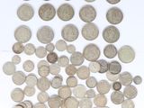 some silver coins are scattered on a white surface