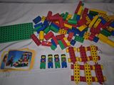 a pile of legos on a bed next to a picture frame
