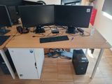 a desk with three computer monitors and a keyboard on it