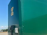 a green semi truck parked in a parking lot