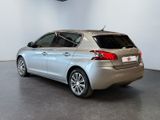the back of a silver car is parked in a white room